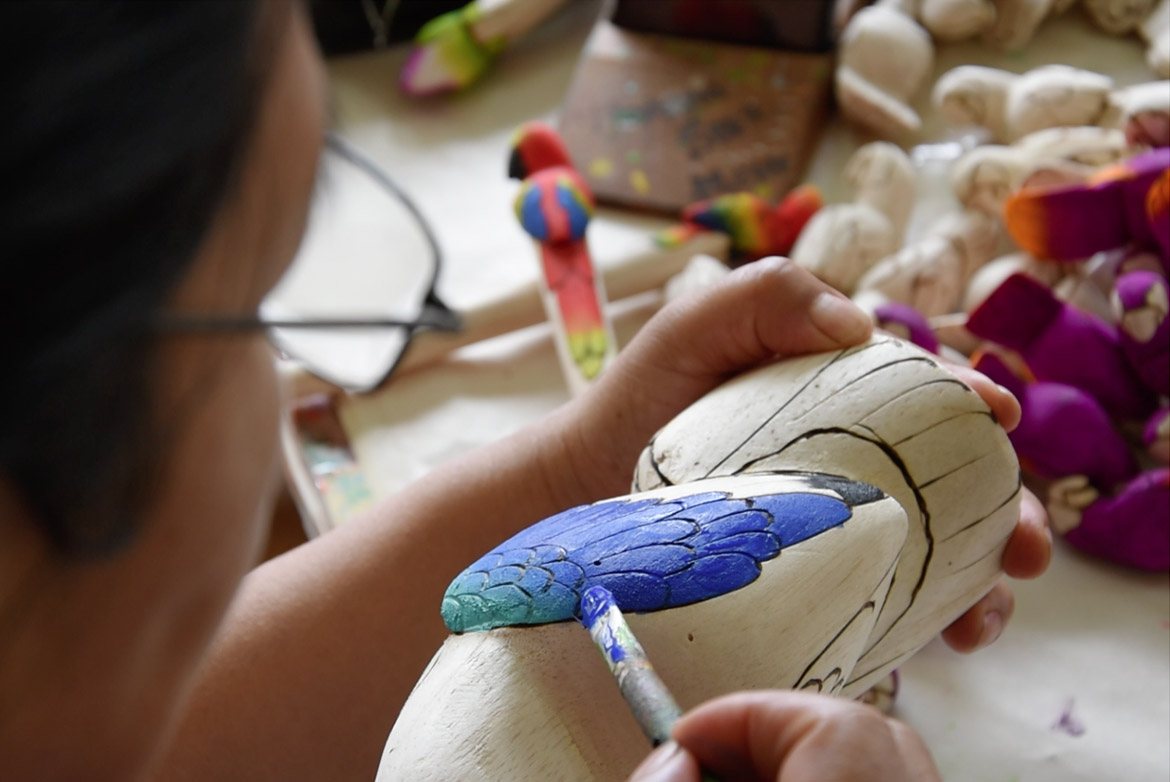 working hands creating a balsa statue